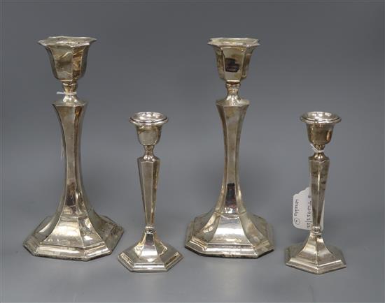 A pair of George V silver pillar waisted candlesticks (Chester 1911) and a smaller pair of candlesticks, tallest 25.3cm.